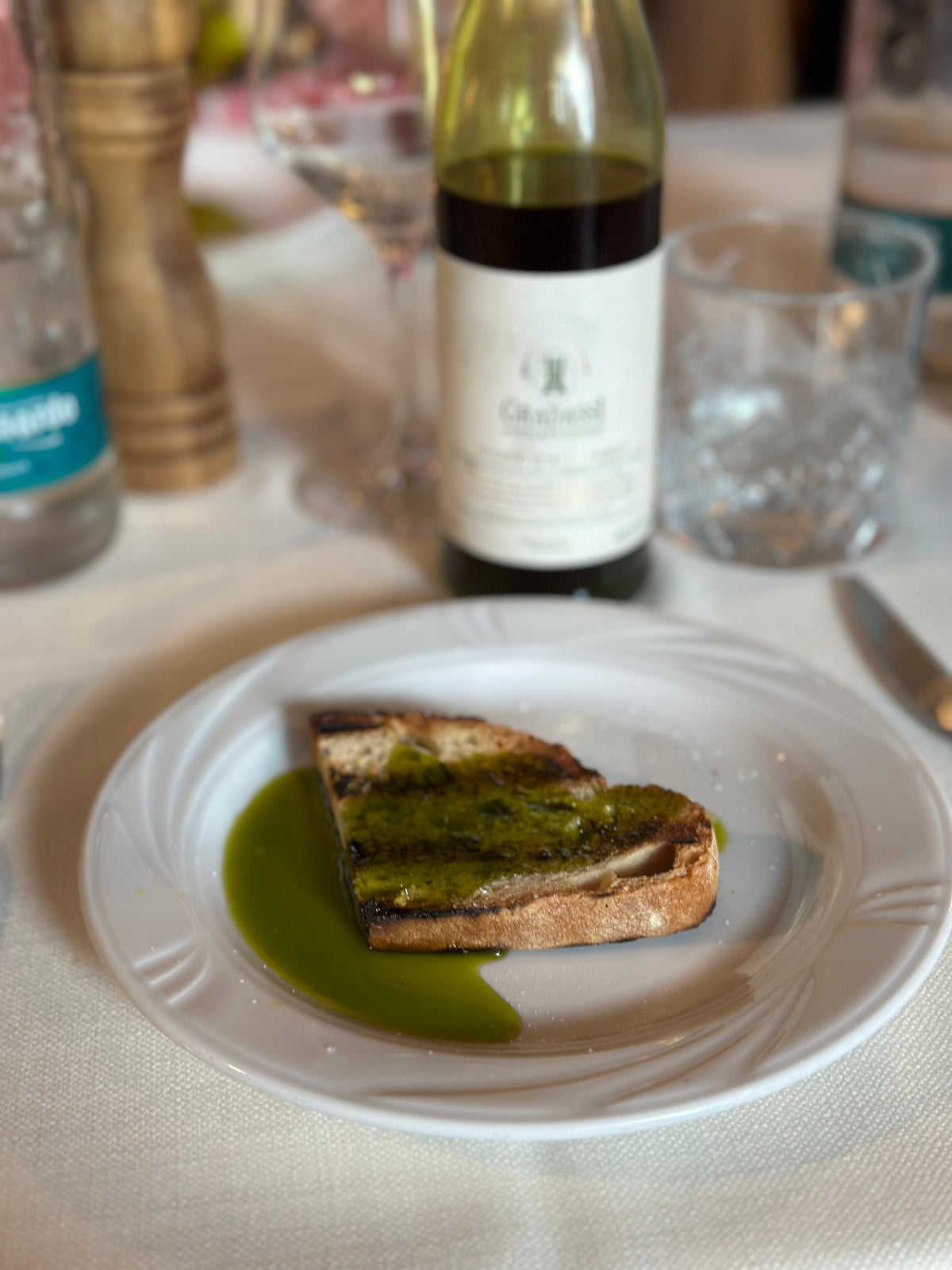 Novello olive oil poured over bruschetta at table